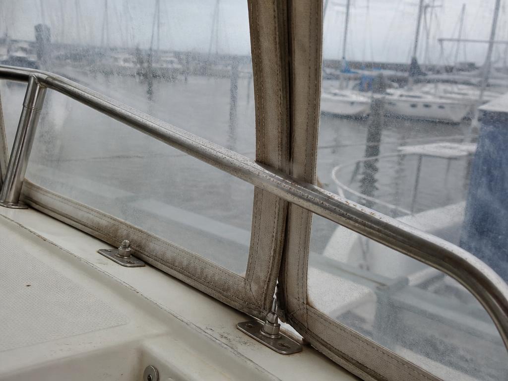 Dull spotted stainless rail and hazy isinglass before polishing